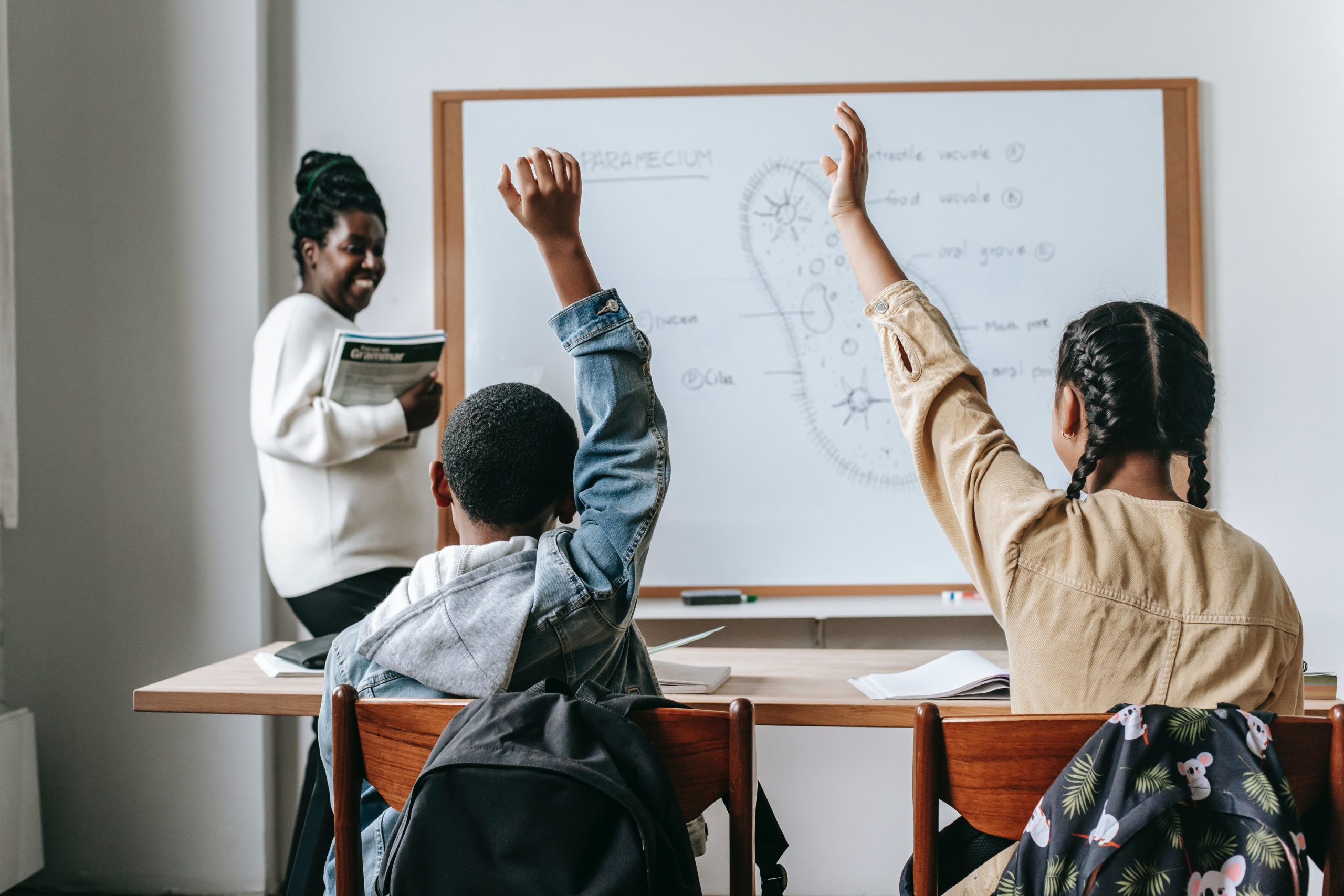 mother teaching son and helping with homework at home, son giving high five to mother