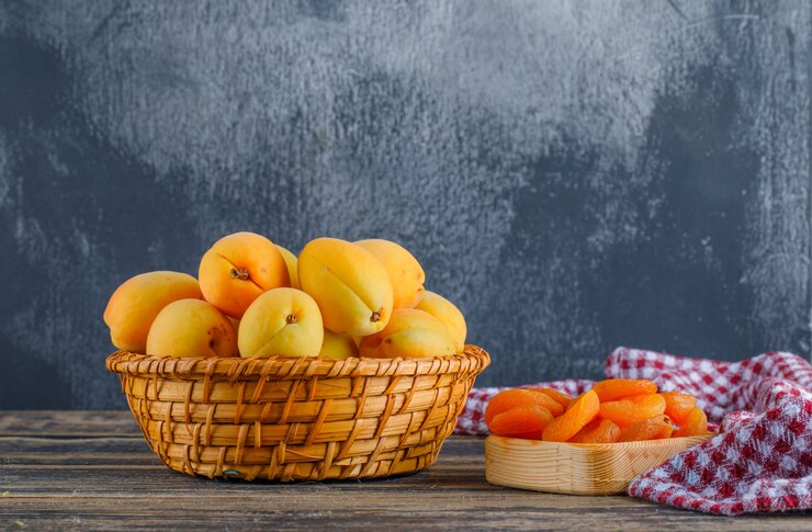 apricots with dried apricots picnic cloth wicker basket plaster wooden table side view 176474 9194