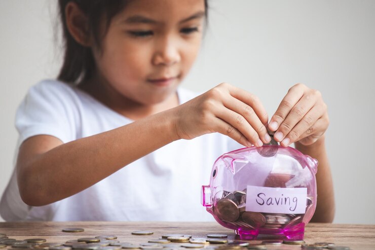 close up girl inserting coins piggy bank table 1048944 16932781